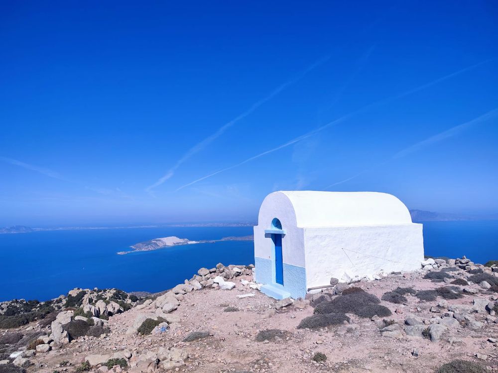 Kleine weiße Kapelle auf einer Bergkuppe über dem Meer